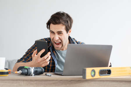 Purchase problem, bad service and negative facial emotions. Angry upset excited young man yelling in...