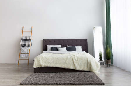 Simple furniture for modern contemporary apartment design. Bed with blanket and pillows, mirror,...