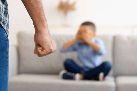 Black Father Clenching Fist Ready To Hit Scared Son Indoorの写真素材