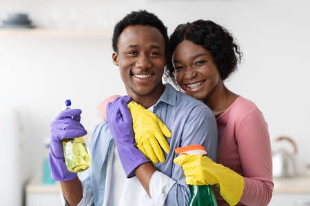Happy black lovers embracing while cleaning houseの写真素材