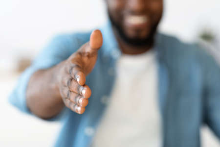 Unrecognizable Black Man Giving Hand For Handshake At Camera, Offering Partnershipの写真素材