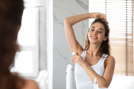 Lady Applying Antiperspirant Roll Underarms For Armpits Freshness In Bathroomの写真素材