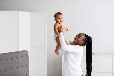 Black mom playing with her cute little baby