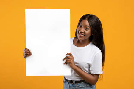 Pretty black woman holding blank board for advertisementの写真素材