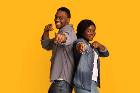 Gotcha. Joyful african man and woman pointing at camera with fingersの写真素材