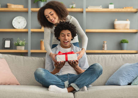 Couple in love celebrating special date or birthday, anniversary present at homeの写真素材