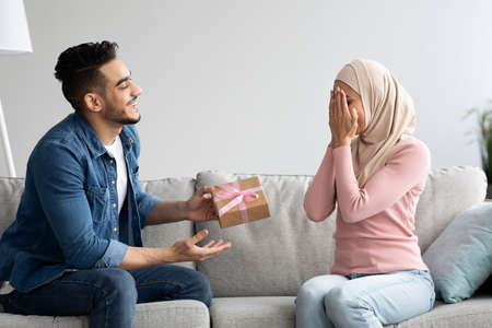 Loving middle-eastern man giving present to his wifeの写真素材