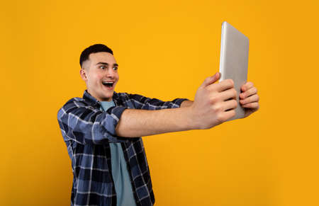 Shocked young guy looking at tablet screen in surprise, reading unbelievable news, cannot believe...
