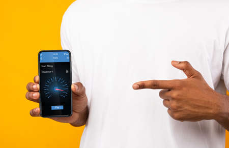 Unrecognizable black guy pointing at cellphone screen with mobile fuel shopping application on...