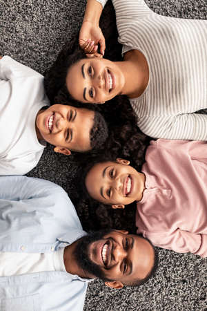 Portrait of black family lying on floor togetherの写真素材