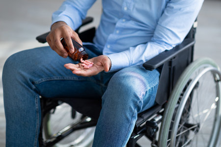 Suicide in people with disability. Handicapped young man pouring handful of pills from jar, closeupの写真素材