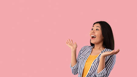Portrait of amazed young asian woman looking at copy spaceの写真素材
