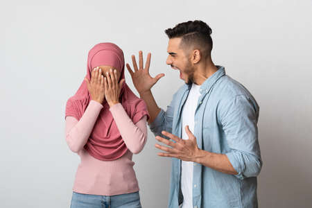 Psychologic Abuse. Furious arab man screaming at his crying muslim wifeの写真素材
