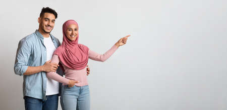 Look There. Happy Middle Eastern Family Pointing Aside At Copy Space