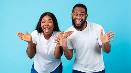 Portrait of excited black couple hearing great news