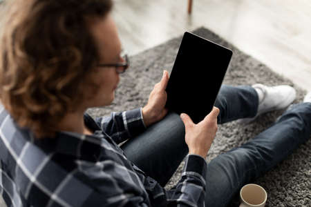 Guy Using Digital Tablet Computer With Empty Screen At Homeの写真素材