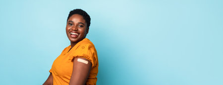 Joyful Vaccinated African American Lady Posing After Injection, Blue Backgroundの写真素材