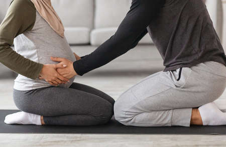 Couples Pregnancy Yoga. Cropped Shot Of Muslim Spouses Training Together At Homeの写真素材