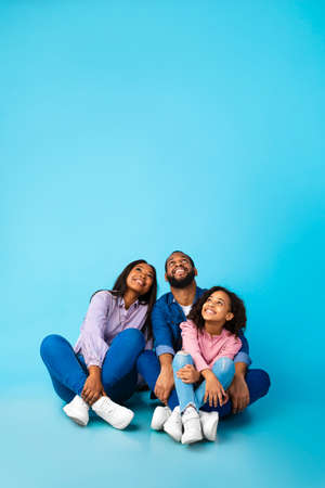 Smiling black family looking up at free copy spaceの写真素材