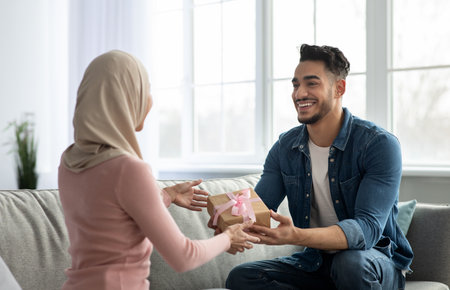 Handsome arab man giving gift box his wifeの写真素材