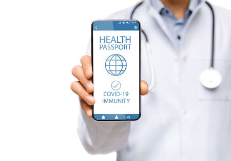 Doctor showing smartphone with Immune digital passport for covid-19の写真素材