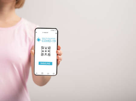 Lady showing mobile phone with Immune digital passport for covidの写真素材