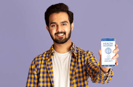 Indian man showing smartphone with immune digital passport for covid-19の写真素材