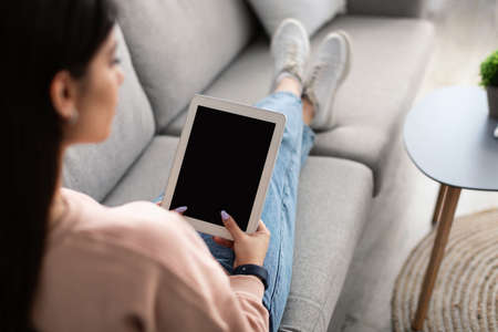Woman using digital tablet with blank empty screen, mockupの写真素材