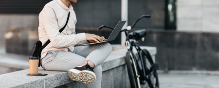Freelance young guy working with computer outside, modern lifestyleの写真素材