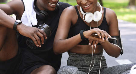 Sport Gadgets. Black Athlete Couple Using Smartwatch Outdoors For Tracking Fitness Activity