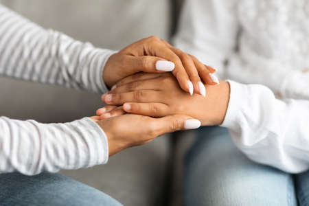 Cropped of black mother holding daughter hands