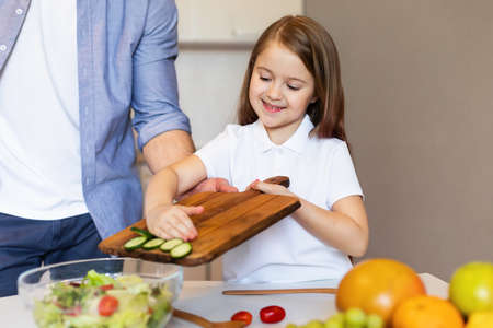 Dad And Little Daughter Cooking Making Salad Together In Kitchenの写真素材