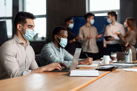 Colleagues working on a project, using laptop computersの写真素材