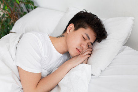 Tired guy gets enough sleep, rest, relax at home in spare time on weekends at morning. Self-isolation for covidの写真素材