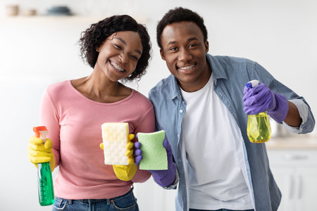 Cheerful african american lovers enjoying house-keeping, closeupの写真素材