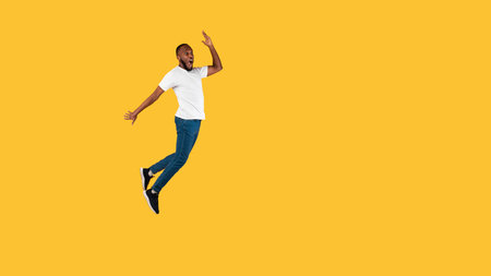Black Guy Jumping Looking Aside In Shock On Yellow Background