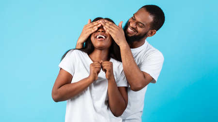 Black man making surprise for his woman, covering her eyes