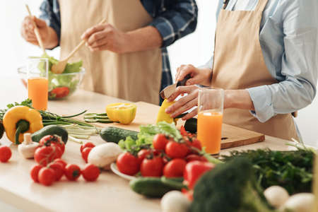 Happy couple at home preparing together yummy dinner for family lunch