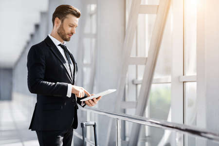 Successful entrepreneur with digital tablet in airportの写真素材