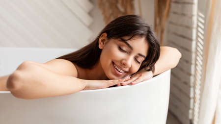 Happy Woman Bathing Lying With Eyes Closed Relaxing In Bathroomの写真素材