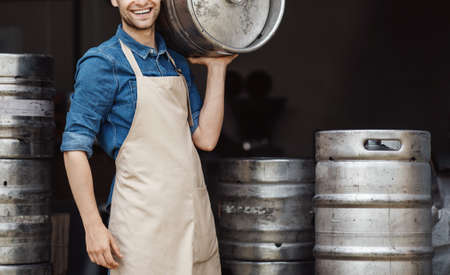 Strong guy works in brewery craft alcohol production. Startup, small business at covid-19の写真素材