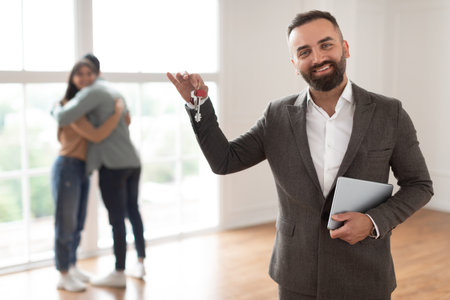 Portrait Of Smiling Real Estate Agent Holding And Showing Keyの写真素材