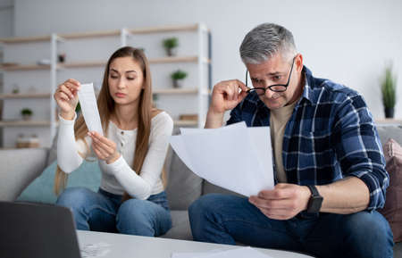 Family budget planning. Married mature couple with documents and bills counting their finances on...