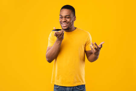 Black Guy Talking On Phone With Loudspeaker Mode, Yellow Background