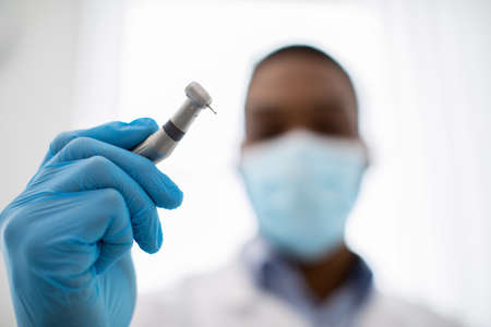 Closeup Shot Of Black Dentist Doctor In Medical Mask Holding Dental Drillの写真素材