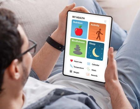 Young man enjoying brand new health app on tabletの写真素材