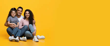 Portrait Of Happy Arab Family With Little Daughter Posing Over Yellow Background