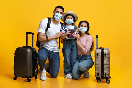 Coronavirus Travels. Arab Family Of Three Wearing Medical Masks Ready For Vacationの写真素材