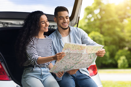Loving middle-eastern couple watching map while having break