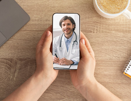 Woman having video call with doctor while working at officeの写真素材